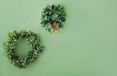 Yeşil duvarda Noel çelenkleri