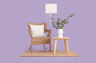 Vazoda bambu saplı masa, leylak arka planda koltuk ve lamba.