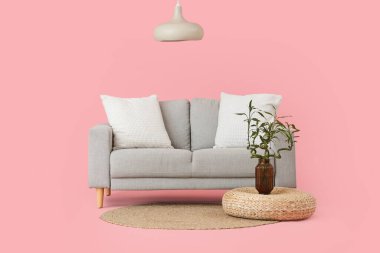 Vazoda, kanepede ve pembe arka planda bambu saplı puf.