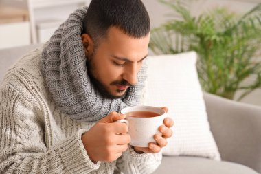 Evde limonlu çay içen genç adam, yakın plan.