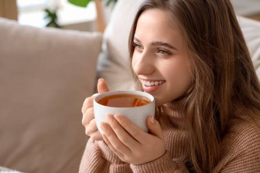 Evde limon çayı içen genç bir kadın, yakın plan.