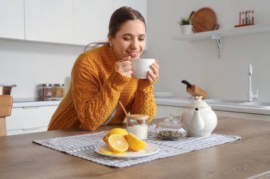 Mutfakta limon çayı olan genç bir kadın.