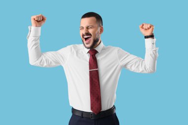 Mavi arka planda kravatı olan duygusal genç iş adamı.