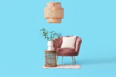 Vazoda bambu saplı masa, koltuk, halı ve lamba mavi arka planda.