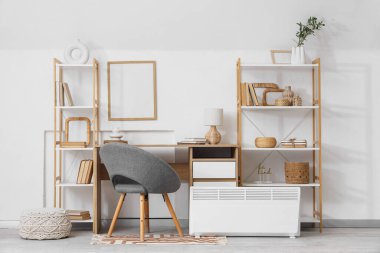 İş yeri, raf üniteleri ve elektrikli konteyner ısıtıcısı olan ışık ofisinin içi