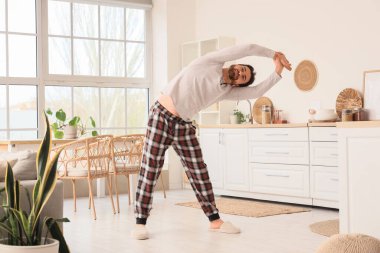 Yakışıklı bir adamın mutfakta egzersiz yaptığı sabah.