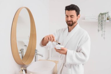 Banyoda diş fırçası ve pudrası olan yakışıklı bir adamın sabahı.