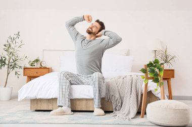 Yakışıklı bir adamın yatak odasında uzandığı bir sabah.