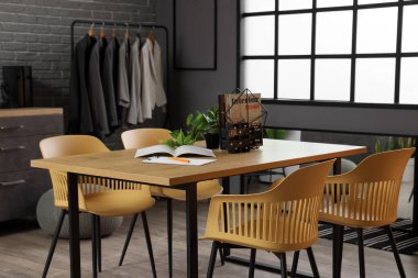 Dergilerle ayakta dur ve giyim mağazasındaki masada bitki yetiştir.