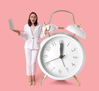 Genç bir iş kadını ve pembe arka planda büyük bir çalar saat. Zaman yönetimi kavramı