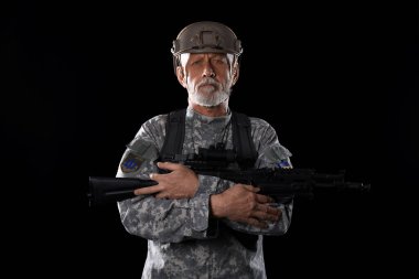 Esmer bir geçmişi olan, saldırı tüfeği olan olgun bir asker.
