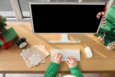 Noel arifesinde bilgisayarla çalışan bir kadın.