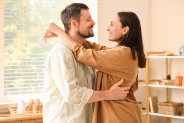 Mutlu genç çift, sonbahar günü evlerinde yatak odasında sarılıyorlar.