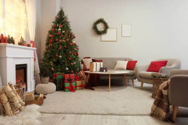 Güzel şöminesi, kanepesi, masası ve süslü Noel ağacı olan şık bir oturma odası.