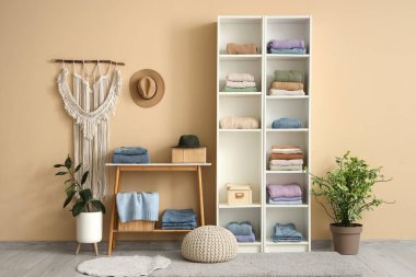 Katlanmış giysileri ve ev bitkileriyle modern soyunma odasının şık bir iç mekanı.