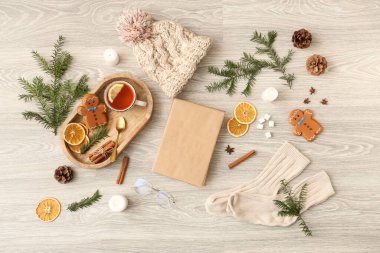 Boş kitaplı kompozisyon, bir fincan çay, baharatlar ve yanan mumlar.