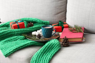 Kakaolu kitaplar, Noel hediyeleri ve kanepede sıcak süveter, yakın plan.