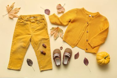 Şık bebek kıyafetleri, patik, balkabağı ve düşmüş yapraklı kompozisyon