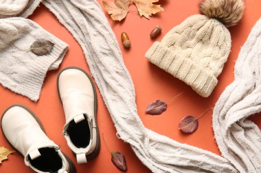 Sıcak çocuk şapkası, atkısı, ayakkabısı ve düşmüş yaprakları olan kompozisyon