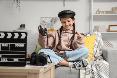 Evde kanepede oturan film makaralı tatlı kız.