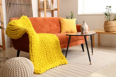 Kanepe ve masada sarı ekoseli rahat bir oturma odası.