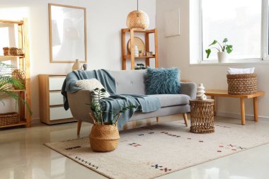 Gri kanepeli, masa ve raf üniteli oturma odasının içi.