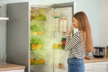 Mutfaktaki dolaptan kötü kokan kadın.