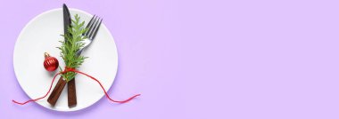 Noel topu ve eflatun arkaplanlı kozalaklı dallı güzel bir masa. Tasarım için pankart