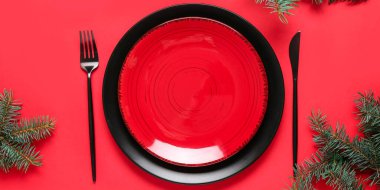 Kırmızı arka planda Noel ağacı dalları olan güzel bir masa.