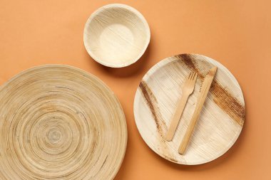 Tahta tabaklar, kase ve bej arka planda çatal bıçak.