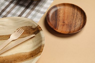 Ahşap tabaklar ve bej arka planda çatal bıçak takımı, yakın plan.