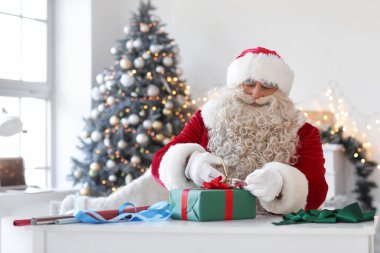 Noel Baba evde Noel hediyesi yapıyor.