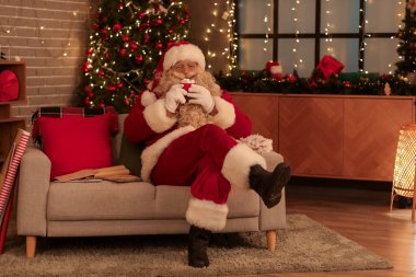 Noel Baba, Noel arifesinde evde lokumla sıcak çikolata içiyor.