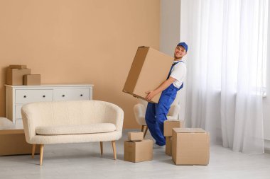 Taşınırken evde karton kutu taşıyan yükleyici
