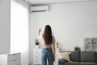 Klimalı, uzaktan kumandalı genç bir kadın.