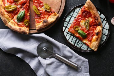 Lezzetli pizzalı kompozisyon ve koyu arkaplanda kesici.