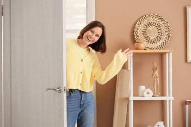 Koridordaki açık kapıdaki mutlu genç kadın