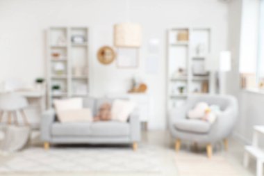 Yumuşak kanepeli, raflı, bulanık manzaralı, şık bir oturma odası.