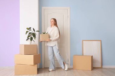 Taşındığı gün salonda karton kutuları olan güzel genç bir kadın.