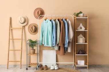 Giysi askısı, merdiven ve rafları bej duvarın yanında olan modern soyunma odasının içinde.