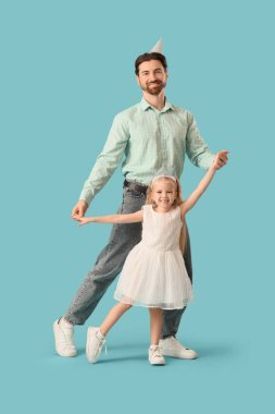 Mavi arka planda küçük kızı olan genç bir adam.