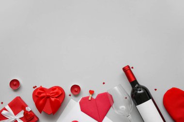 Mumlu hediye kutuları, kağıt kalp ve gri arka planda bir şişe şarap. Sevgililer Günü kutlaması