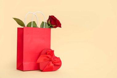 Güzel kırmızı gül ve sarı arka planda hediye paketi. Sevgililer Günü kutlaması