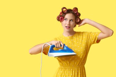 Sarı arka planda demiri olan genç kadın.