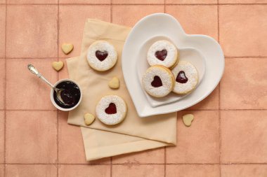 Tatlı kurabiyeli bir tabak ve bej kaplamalı bir kase reçel. Sevgililer Günü kutlaması