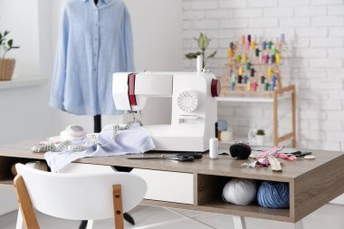 Terzinin dikiş makinesi, farklı malzemeler ve atölye mankeni.