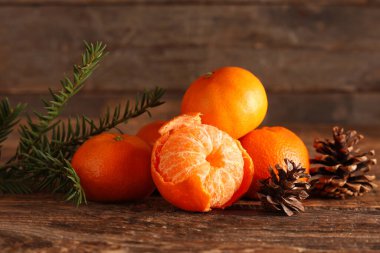 Mandallı tatlı mandalinalar ve ahşap arka planda köknar dalı, yakın plan.