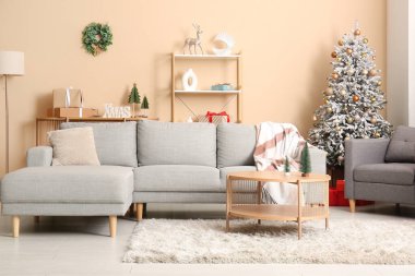 Oturma odasının içinde Noel ağaçları, kanepe ve koltuk var.
