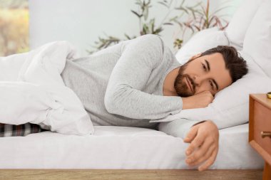 Morning of handsome man lying in bedroom