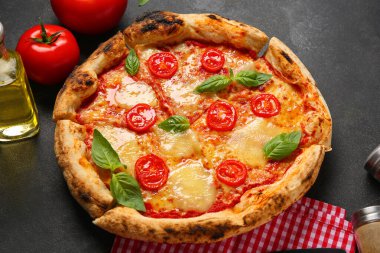 Siyah arka planda fesleğenli lezzetli pizza Margarita.